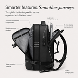 A black backpack shown on a light gray background with callout labels pointing to features such as a vacuum compression compartment, multiple storage pockets, anti-theft combination lock, 16-inch laptop compartment, water-resistant material, expandable main compartment, and USB-C charging port.