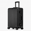 A black hard-shell spinner suitcase with a vertical ribbed design, telescoping handle, and four wheels, shown on a light gray background.
