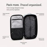 An open blue travel organizer bag shown on a light beige background with callout labels pointing to interior storage features: zipped separation pocket, breathable mesh pocket, built-in compression compartment, spacious main compartment, and organized interior storage.