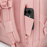 Close-up of a dusty pink backpack with a side zipper pocket containing a smartphone and a matching pink card holder, showing the textured fabric and mesh back panel.