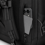 Close-up of a black backpack with a side zipper pocket containing a smartphone and a gray card, showing the pocket opening, zipper, mesh backing, and white contrast stitching.