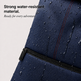 Close-up of a navy blue waterproof backpack with water droplets on the surface, featuring a zipper and red contrast stitching. Text on the left reads 'Strong water-resistant material.