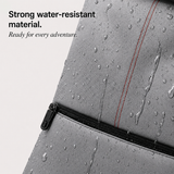 Close-up of a gray waterproof bag with water droplets on the surface, a zipper, and red stitching, with text reading 'Strong water-resistant material. Ready for every adventure.