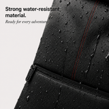 Close-up of a black waterproof backpack or bag with water droplets on the surface, a horizontal zipper, and a red stitched accent line. Text on the left reads, 'Strong water-resistant material.