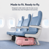 A pink suitcase sits underneath an airplane seat in a clean cabin setting, with marketing text at the top about fit and readiness for travel.