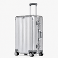 A silver aluminum ribbed hard-shell suitcase with four spinner wheels, an extended telescopic handle, and dual lock latches, shown on a light gray background.