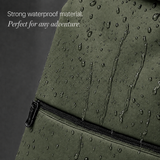 Close-up of an olive green waterproof backpack with water droplets and running water on the surface, featuring a zipper and text that reads 'Strong waterproof material. Perfect for any adventure.